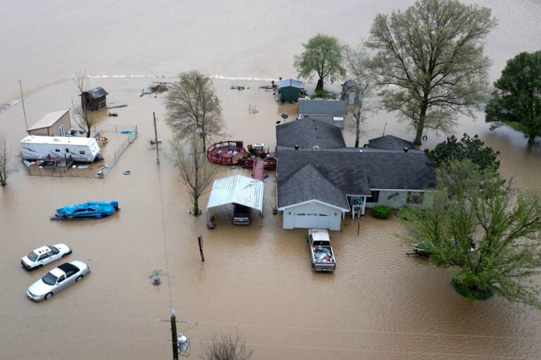 An aerial view shows floodwaters surrounding a rural home