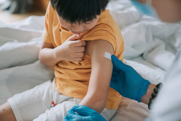 doctor applying bandage after vaccinating child