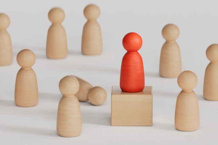 wooden pawn followers gathered around leader